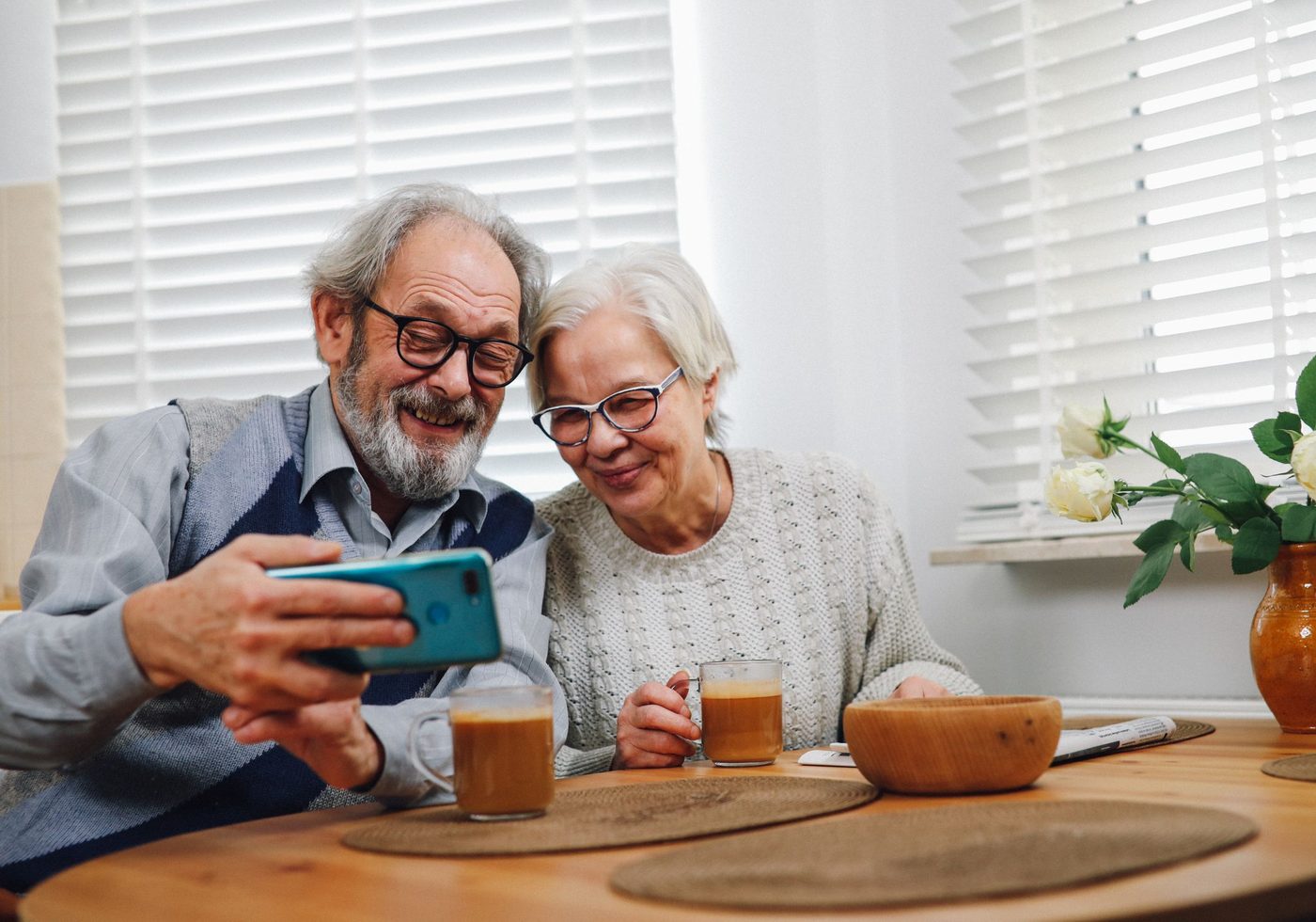 An older couple at home looking at a phone together